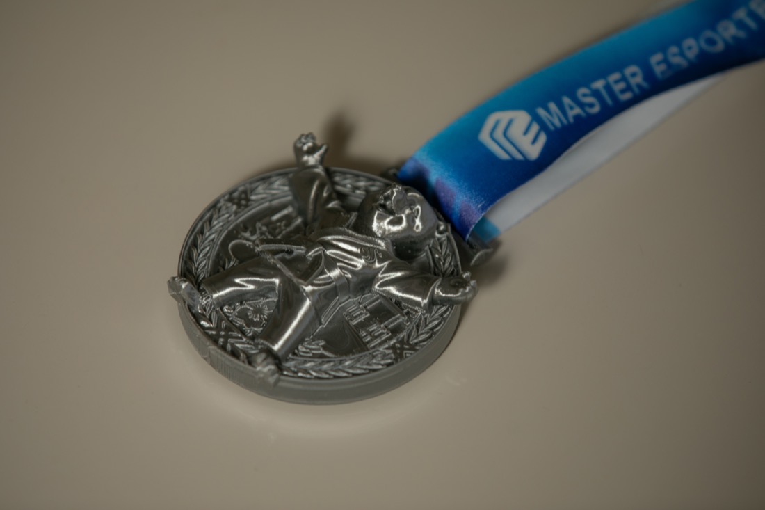 Medalha 3D em acabamento prata com fita azul.